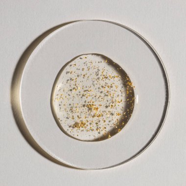 Beyaz zemin üzerinde altın olan bir damla serum, kozmetik dokular, cilt ürünü lekesi yüz serumu, yağ