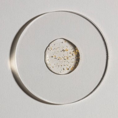 Beyaz zemin üzerinde altın olan bir damla serum, kozmetik dokular, cilt ürünü lekesi yüz serumu, yağ