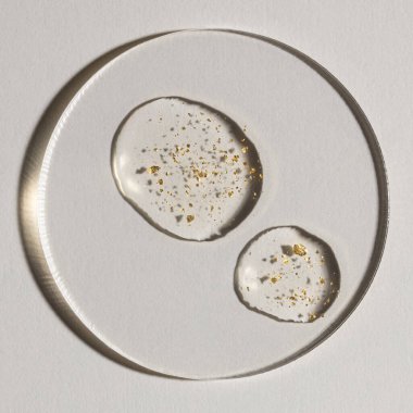 Beyaz zemin üzerinde altın olan bir damla serum, kozmetik dokular, cilt ürünü lekesi yüz serumu, yağ