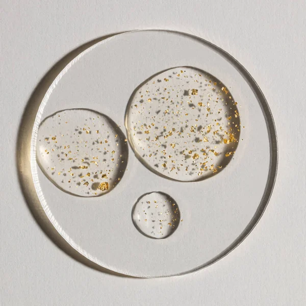 Beyaz zemin üzerinde altın olan bir damla serum, kozmetik dokular, cilt ürünü lekesi yüz serumu, yağ