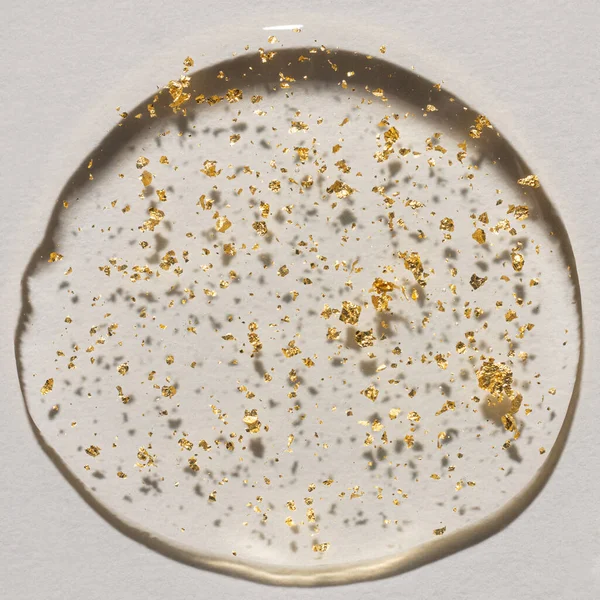 Beyaz zemin üzerinde altın olan bir damla serum, kozmetik dokular, cilt ürünü lekesi yüz serumu, yağ