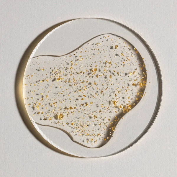 Beyaz zemin üzerinde altın olan bir damla serum, kozmetik dokular, cilt ürünü lekesi yüz serumu, yağ