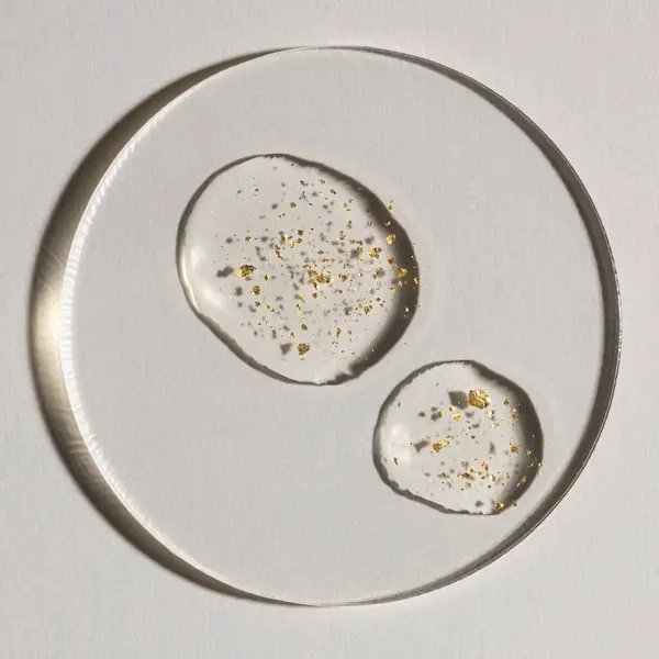 Beyaz zemin üzerinde altın olan bir damla serum, kozmetik dokular, cilt ürünü lekesi yüz serumu, yağ