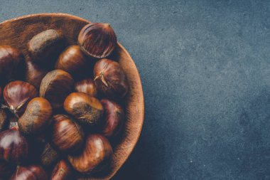 Raw  roasted chestnuts on black background