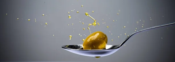 Olive Oil Splashing Olive Metal Spoon — Stock Photo, Image