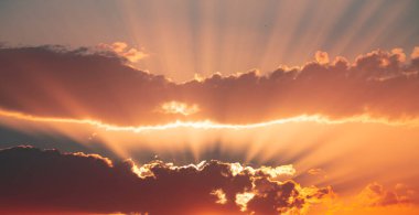 Gün batımında bulutların arkasında ışık huzmesi