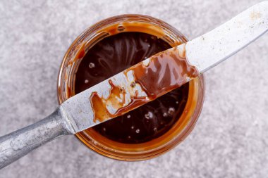 Eski arkaplanda karamel reçeli ve bıçak