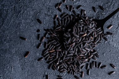 Çiğ pirinç ve metal kaşık.