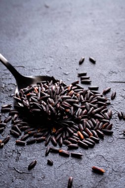 Çiğ pirinç ve metal kaşık.
