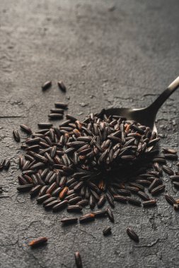 Çiğ pirinç ve metal kaşık.