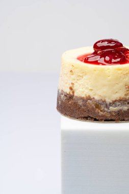 Beyaz arka planda ahududulu peynirli pasta.