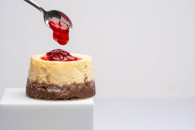 Beyaz arka planda ahududulu peynirli pasta.