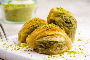 Beyaz arka planda fıstıklı midye şekilli baklava