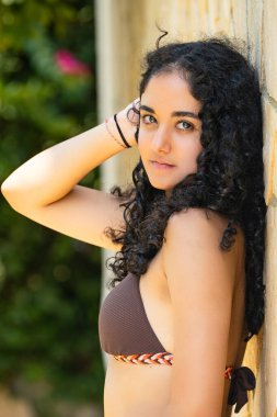 Yaz zamanı ve bikinili genç kız güneşleniyor.