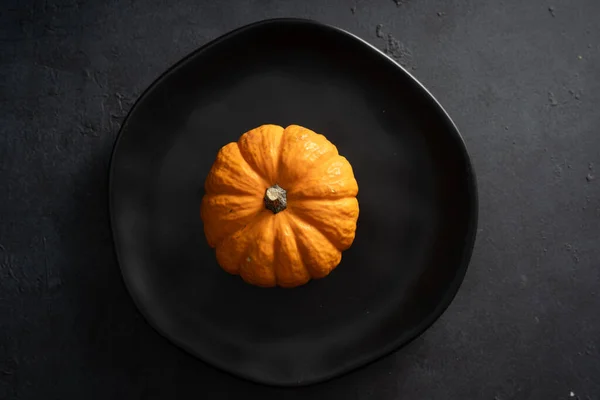 Mini pumpkins on black background