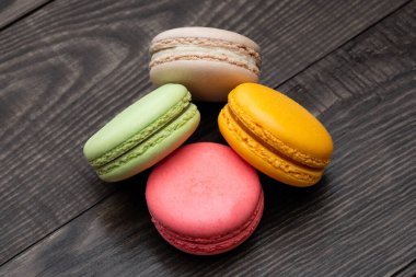 Ahşap arka planda tatlı ve renkli badem kurabiyeleri