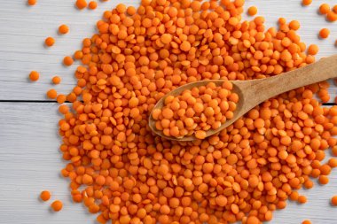 Beyaz ahşap arka planda pişmemiş mercimek