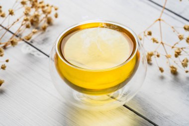 Beyaz taştan arka planda bir bardak çay ya da bitki çayı.