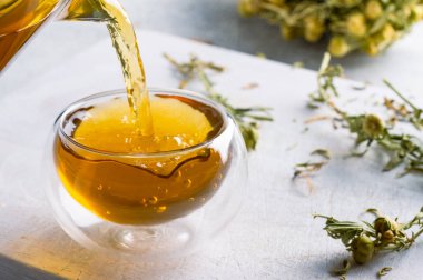 Beyaz taştan arka planda bir bardak çay ya da bitki çayı.