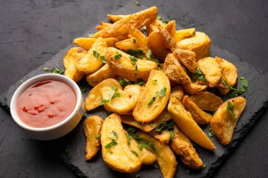Siyah arka planda lezzetli patates dilimleri