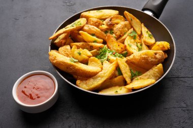 Siyah arka planda lezzetli patates dilimleri