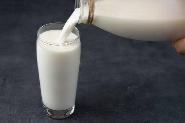 Siyah arka planda günlük taze inek sütü