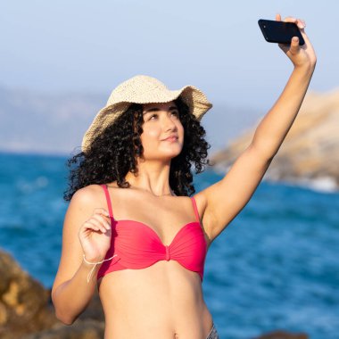 Sahilde şapkalı güzel bir kız.