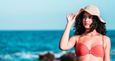 Sahilde şapkalı güzel bir kız.