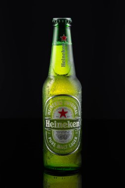 Üstünde su damlaları olan soğuk bir Heineken bira şişesi..