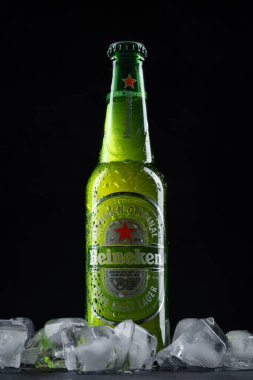 Üstünde su damlaları olan soğuk bir Heineken bira şişesi..