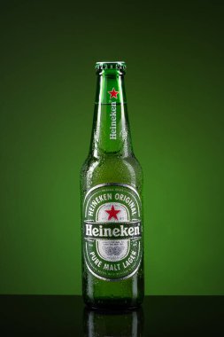 Üstünde su damlaları olan soğuk bir Heineken bira şişesi..