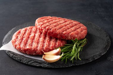 Siyah arka planda izole edilmiş çiğ hamburger köftesi..