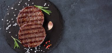 Siyah arkaplanda pişmiş hamburger köftesi..