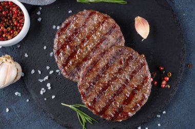 Siyah arkaplanda pişmiş hamburger köftesi..