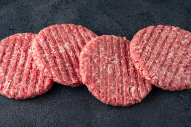 Siyah arka planda izole edilmiş çiğ hamburger köftesi..