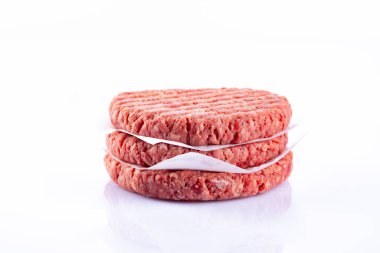 Beyaz arka planda izole edilmiş çiğ hamburger köftesi..