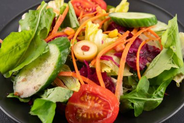 Sağlıklı beslenmek için siyah arka planda taze salata.