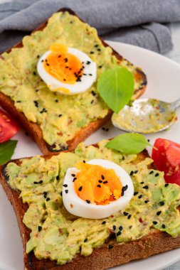Sağlıklı avokado tostları ve masada yumurtalar.