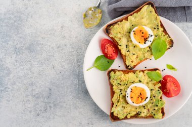 Sağlıklı avokado tostları ve masada yumurtalar.