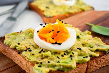 Sağlıklı avokado tostları ve masada yumurtalar.