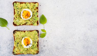 Sağlıklı avokado tostları ve masada yumurtalar.
