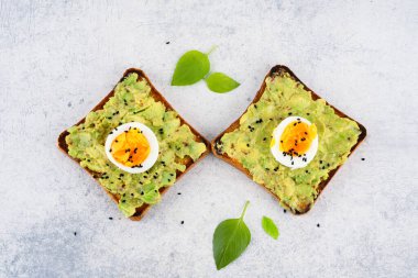 Sağlıklı avokado tostları ve masada yumurtalar.