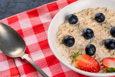Kahvaltı için yaban mersinli, çilekli sütlü yulaf lapası.