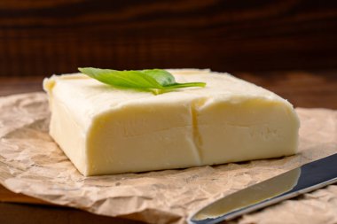 Yemeklere lezzet katan tereyağı ve ahşap bir arka planda kahvaltı içindir.