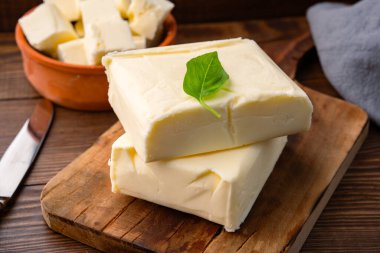 Yemeklere lezzet katan tereyağı ve ahşap bir arka planda kahvaltı içindir.