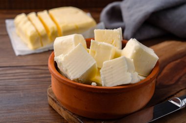 Yemeklere lezzet katan tereyağı ve ahşap bir arka planda kahvaltı içindir.