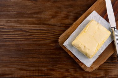 Yemeklere lezzet katan tereyağı ve ahşap bir arka planda kahvaltı içindir.