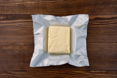 Yemeklere lezzet katan tereyağı ve ahşap bir arka planda kahvaltı içindir.