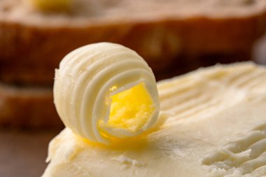 Yemeklere tat katan tereyağı. Kahverengi eskimiş arka planda kahvaltı için.