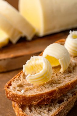 Yemeklere lezzet katan tereyağı ve ahşap arka planda kahvaltı içindir.